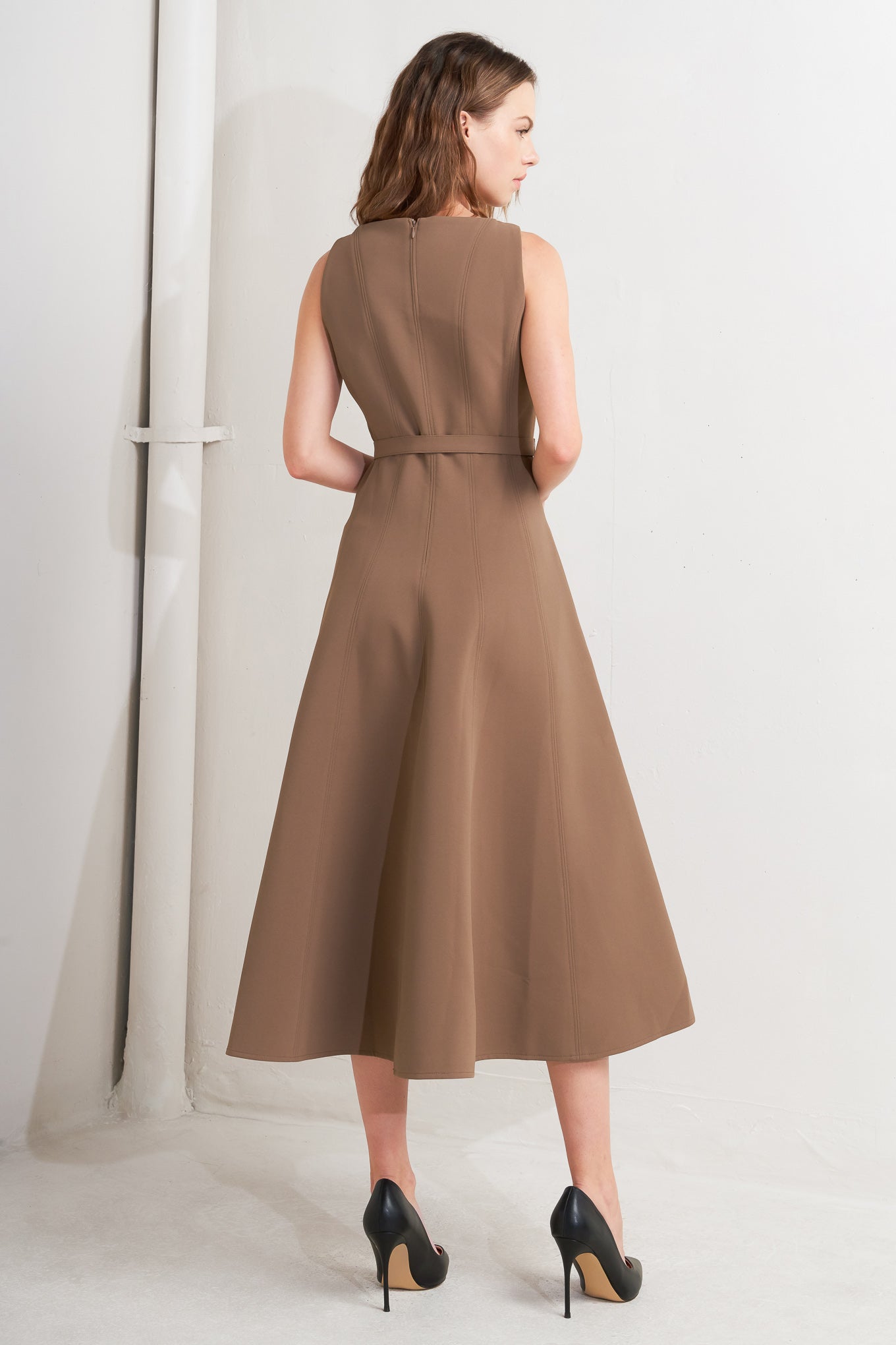 A solid woven midi dress featuring boat neckline, sleeveless, full skirt, self belt, side pocket and full skirt