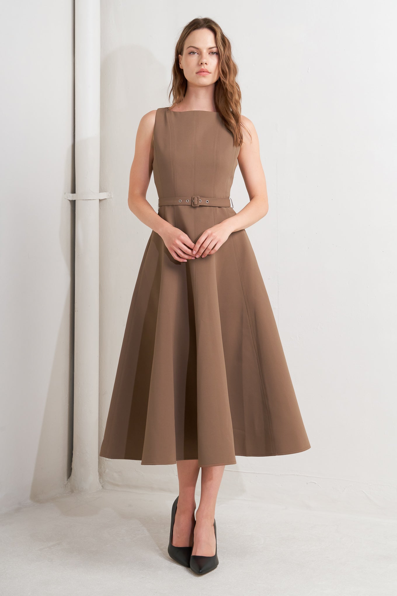 A solid woven midi dress featuring boat neckline, sleeveless, full skirt, self belt, side pocket and full skirt