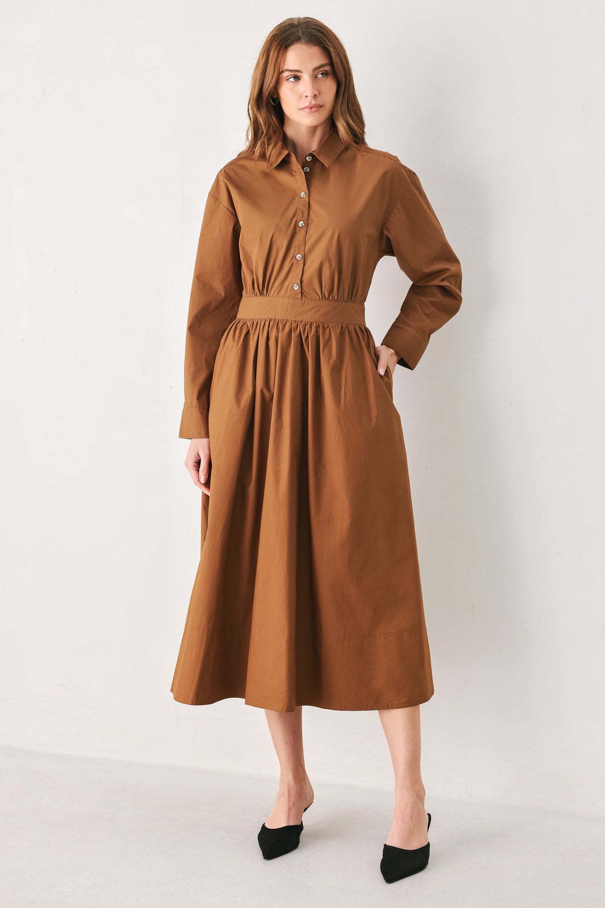A woman modeling a rust long-sleeve midi shirt dress with a button-up front and gathered waist | FREEMARKET