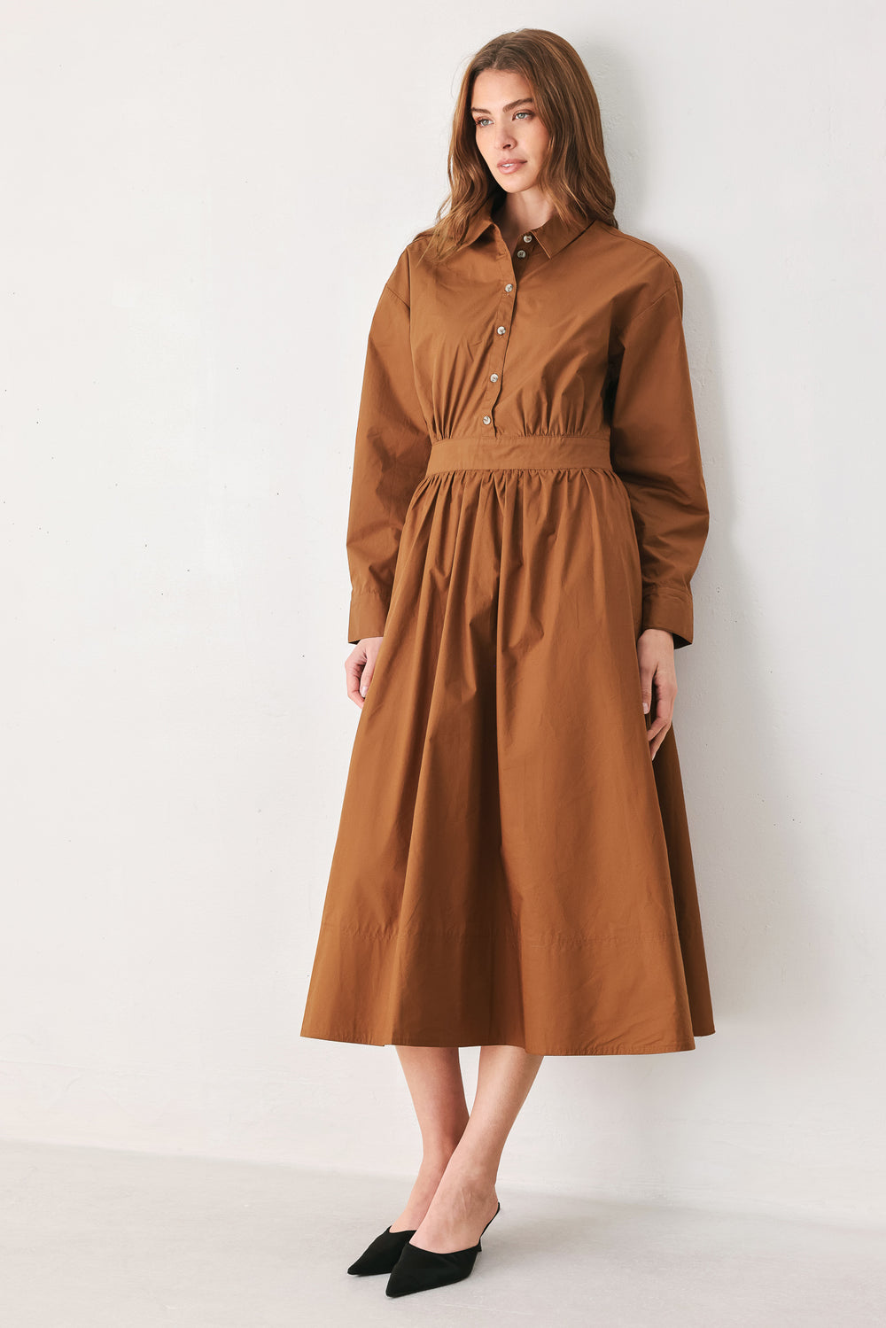 A woman modeling a rust long-sleeve midi shirt dress with a button-up front and gathered waist | FREEMARKET