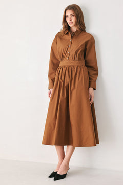 A woman modeling a rust long-sleeve midi shirt dress with a button-up front and gathered waist | FREEMARKET