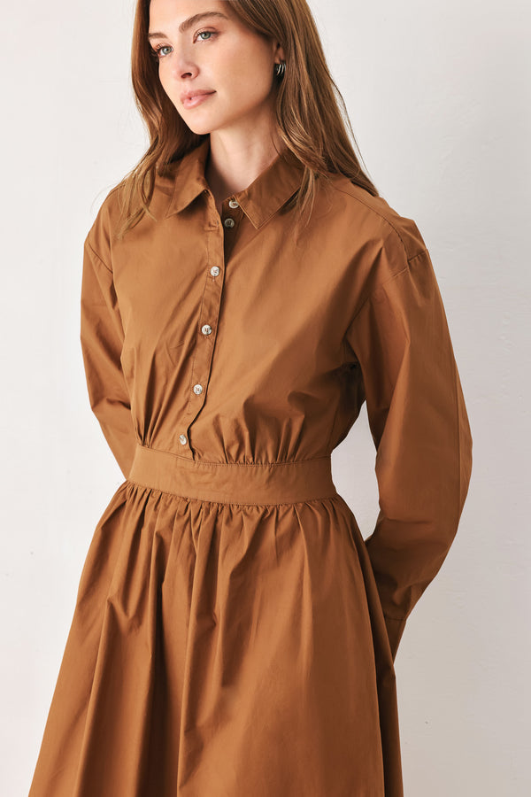 A woman modeling a rust long-sleeve midi shirt dress with a button-up front and gathered waist | FREEMARKET