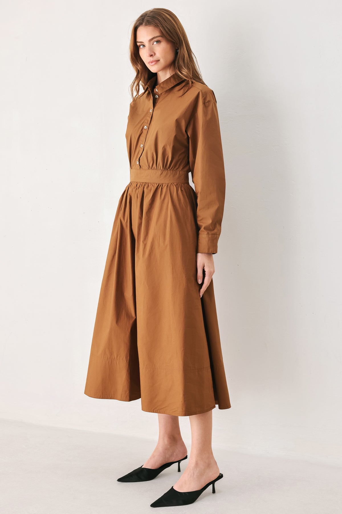A woman modeling a rust long-sleeve midi shirt dress with a button-up front and gathered waist | FREEMARKET