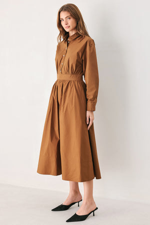 A woman modeling a rust long-sleeve midi shirt dress with a button-up front and gathered waist | FREEMARKET