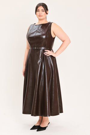 A woman modeling a sleeveless, dark brown faux-leather midi dress with a matching waist belt, paired with black pointed-toe heels and a small black handbag, against a plain light background | FREEMARKET Curve