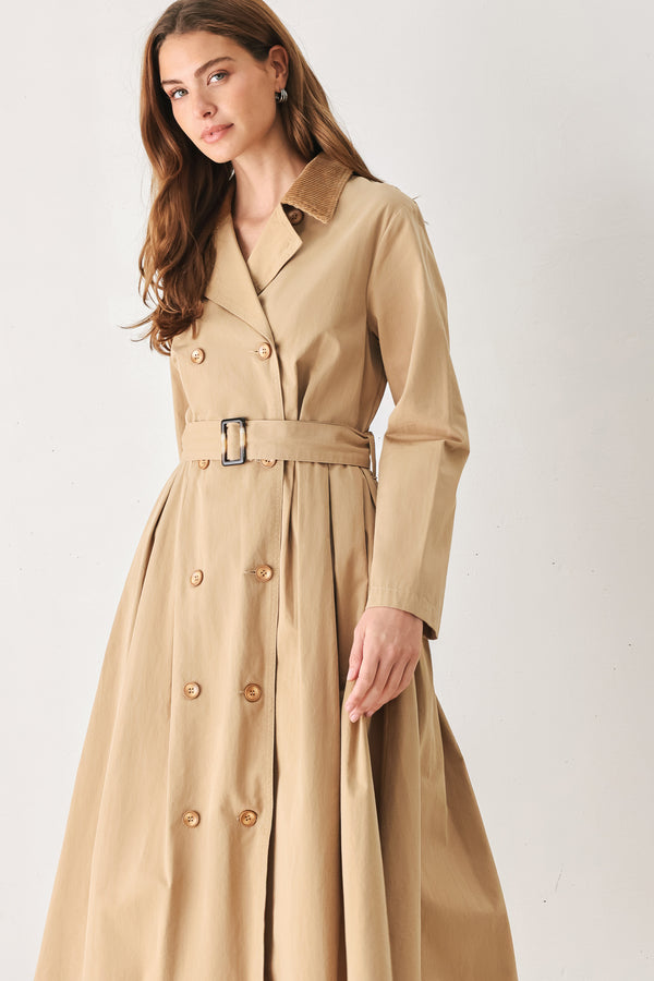 A woman models a beige double-breasted trench coat with a matching waist belt, paired with brown pointed-toe heels | FREEMARKET