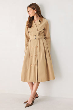A woman models a beige double-breasted trench coat with a matching waist belt, paired with brown pointed-toe heels | FREEMARKET