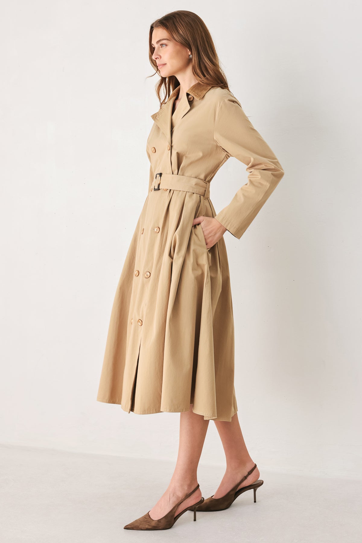 A woman models a beige double-breasted trench coat with a matching waist belt, paired with brown pointed-toe heels | FREEMARKET