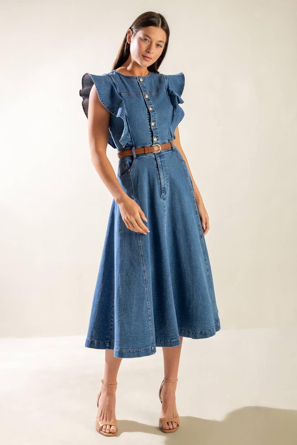 A washed blue denim midi dress featuring round neckline, short ruffled sleeve, front button/zipper closure, side pockets and full skirt.