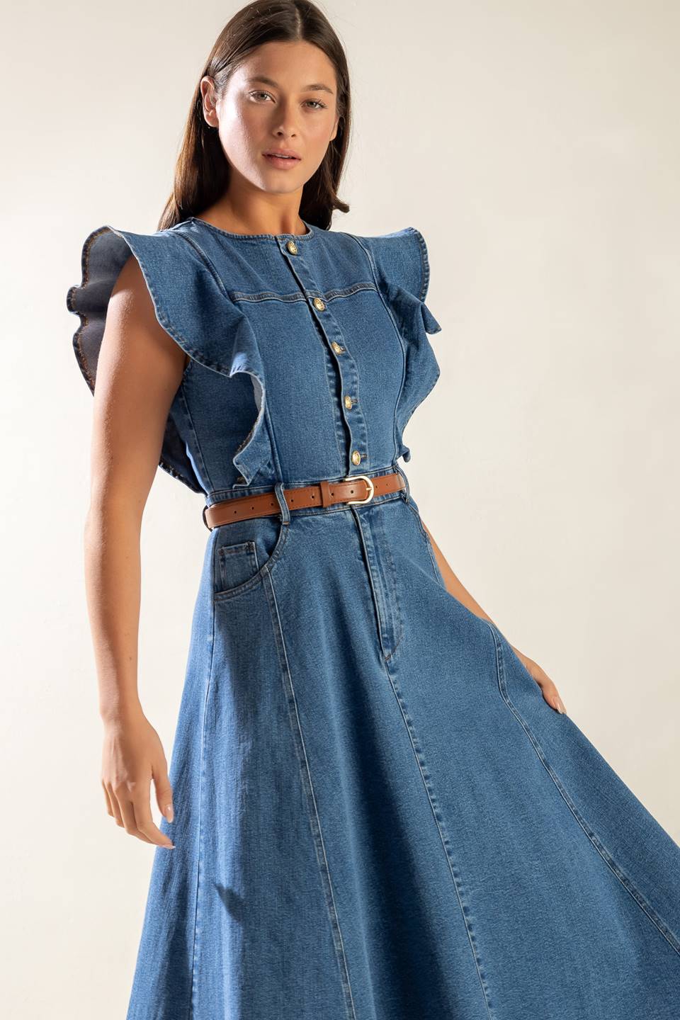 A washed blue denim midi dress featuring round neckline, short ruffled sleeve, front button/zipper closure, side pockets and full skirt.