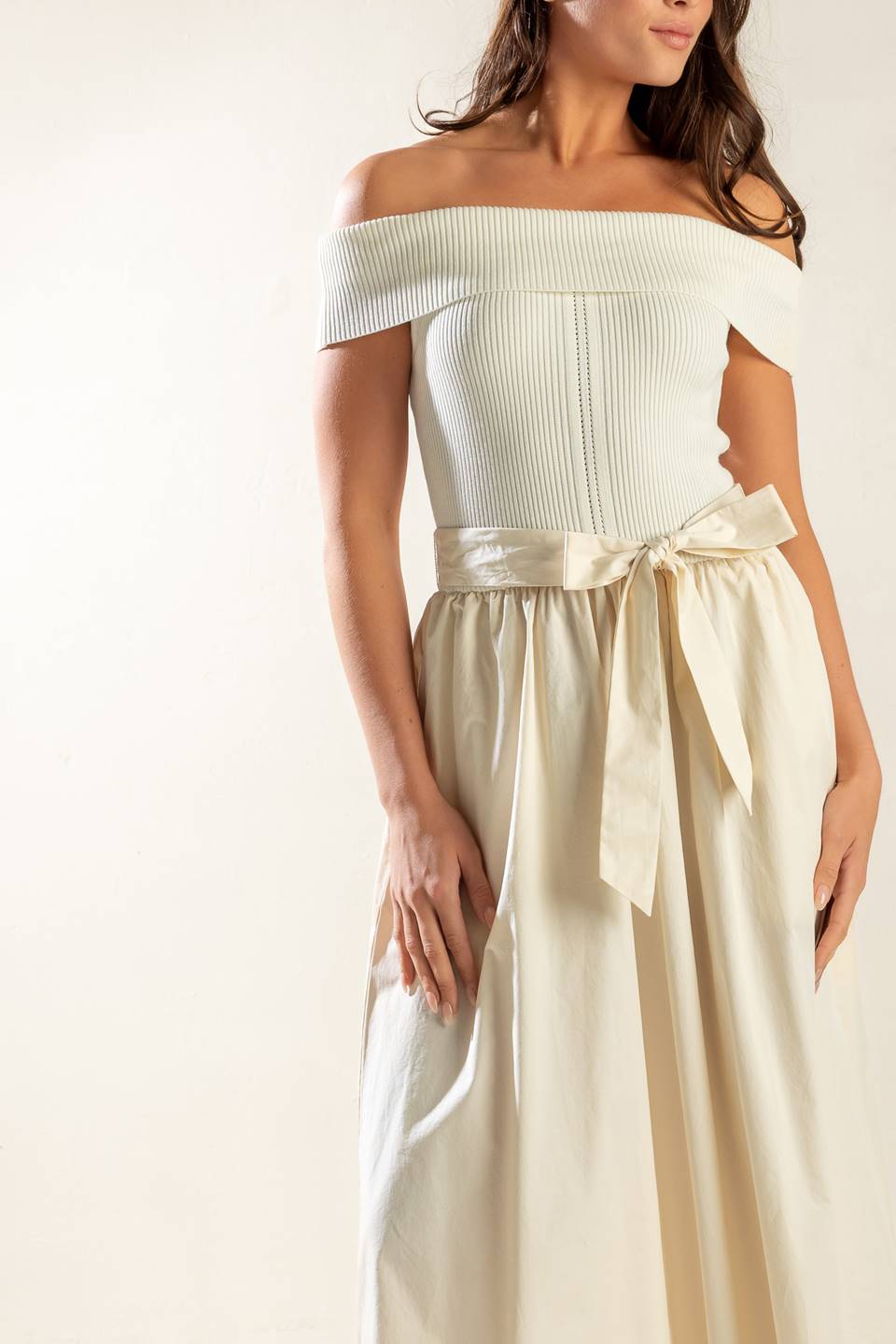 A sweater off shoulder top with full woven skirt and self sash belt.