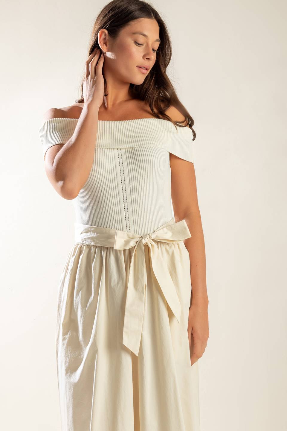 A sweater off shoulder top with full woven skirt and self sash belt.