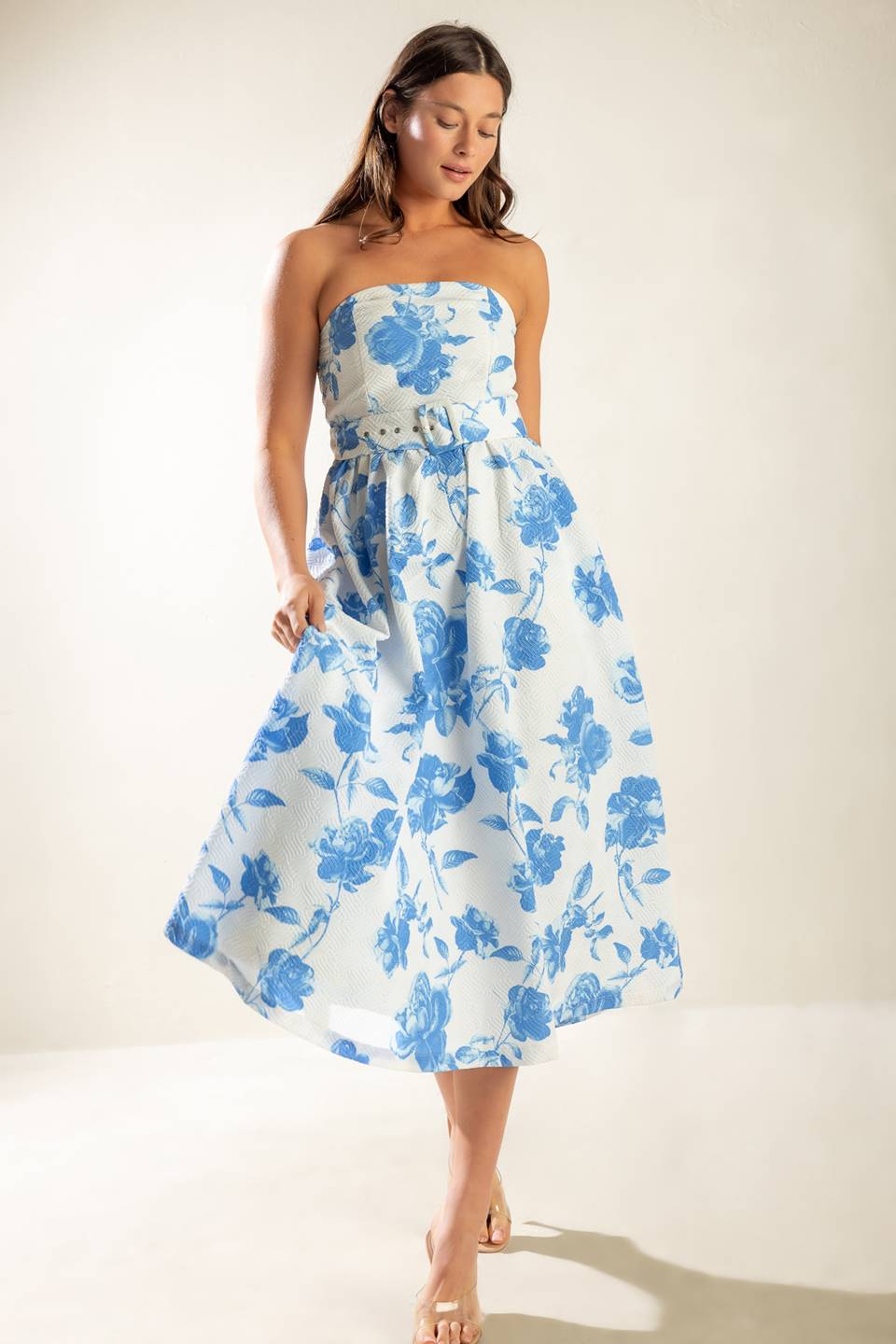 A strapless white and blue printed textured woven midi dress featuring self belt and full skirt.