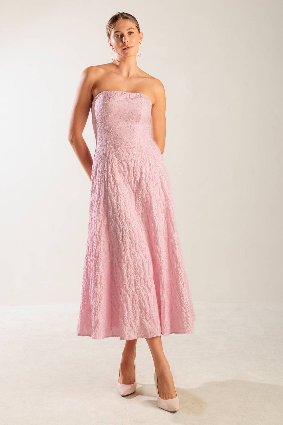 A textured pink woven midi dress featuring strapless, circle skirt and smocked back bodice with zipper closure