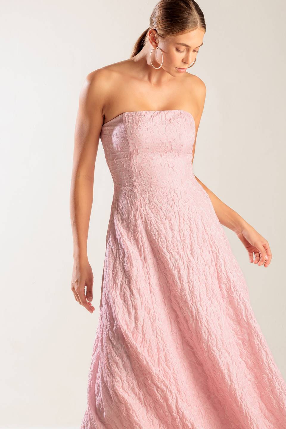 A textured pink woven midi dress featuring strapless, circle skirt and smocked back bodice with zipper closure