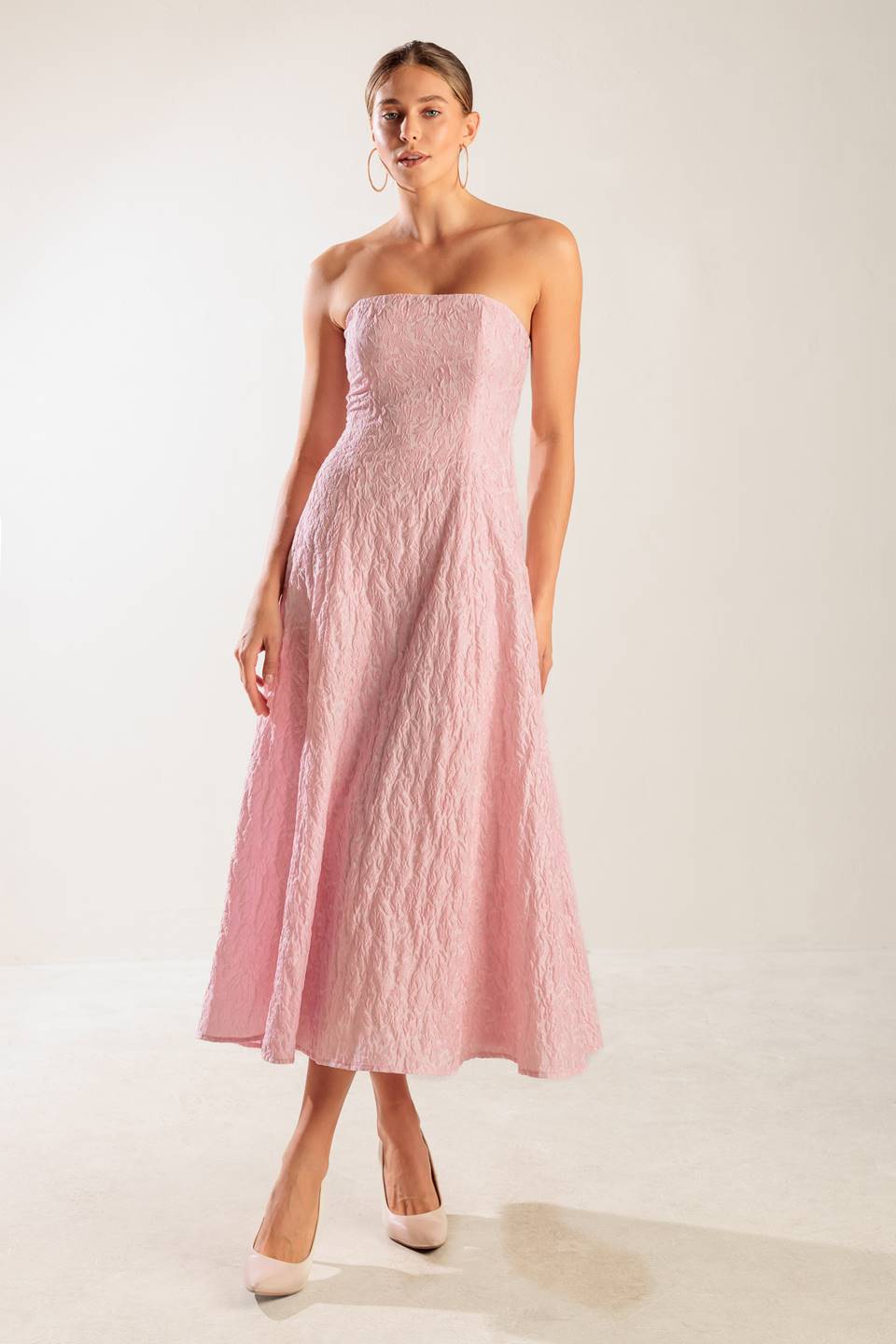 A textured pink woven midi dress featuring strapless, circle skirt and smocked back bodice with zipper closure