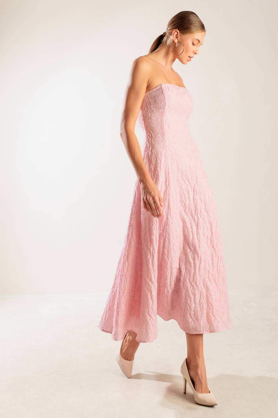 A textured pink woven midi dress featuring strapless, circle skirt and smocked back bodice with zipper closure