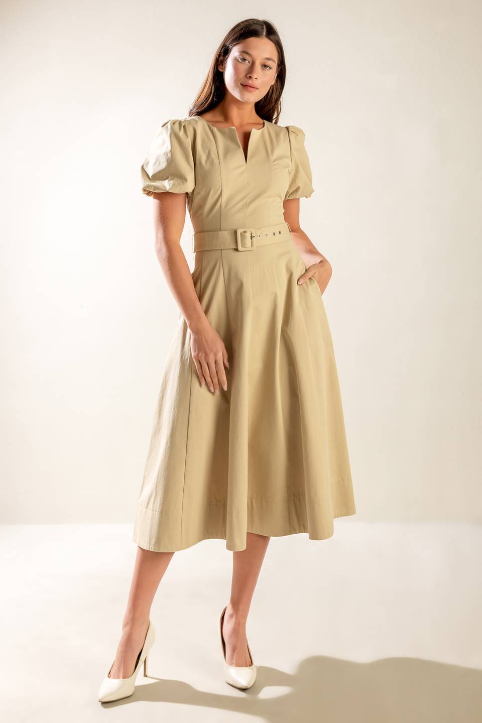 A solid woven midi dress featuring round neckline with V center, short puff sleeve, self belt, circle skirt and back zipper closure