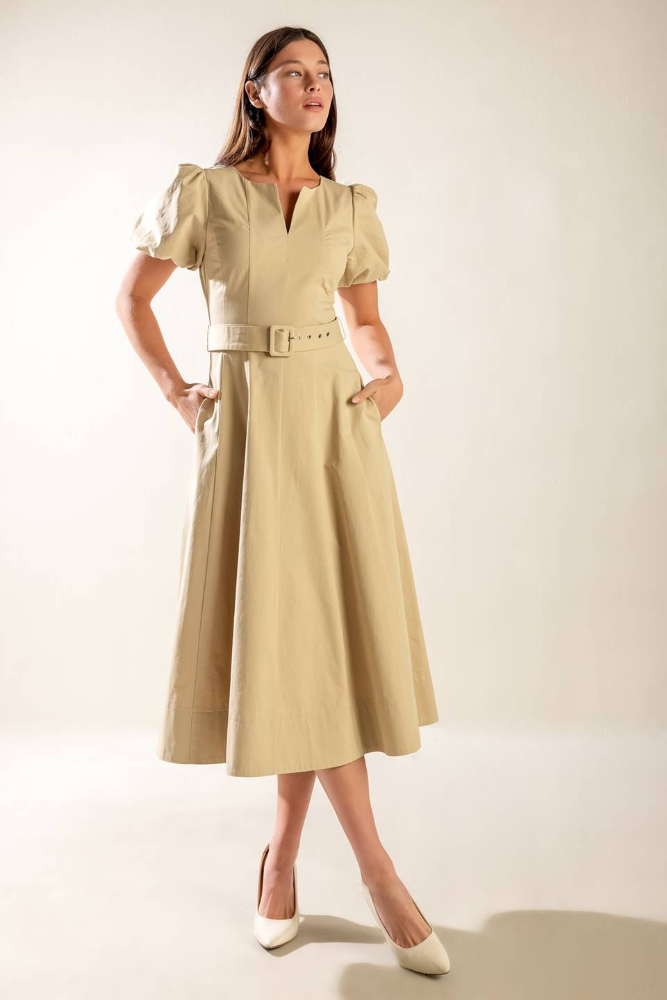 A solid woven midi dress featuring round neckline with V center, short puff sleeve, self belt, circle skirt and back zipper closure