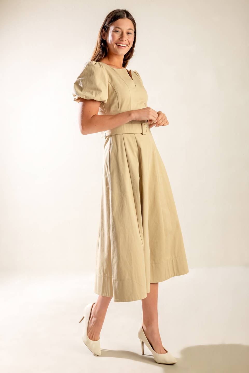 A solid woven midi dress featuring round neckline with V center, short puff sleeve, self belt, circle skirt and back zipper closure