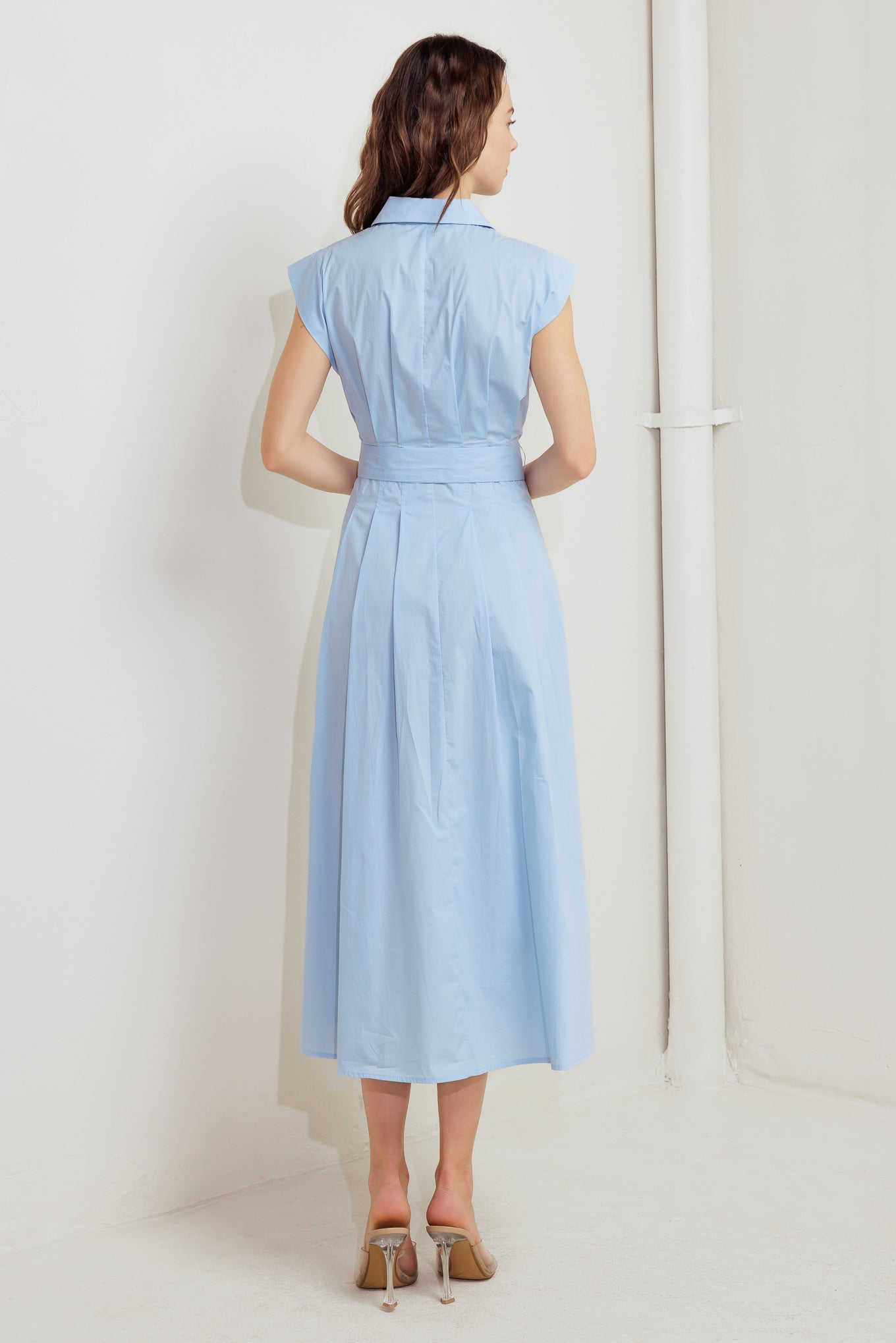A solid woven midi dress featuring collar, short sleeve, front zipper closure and self sash tie