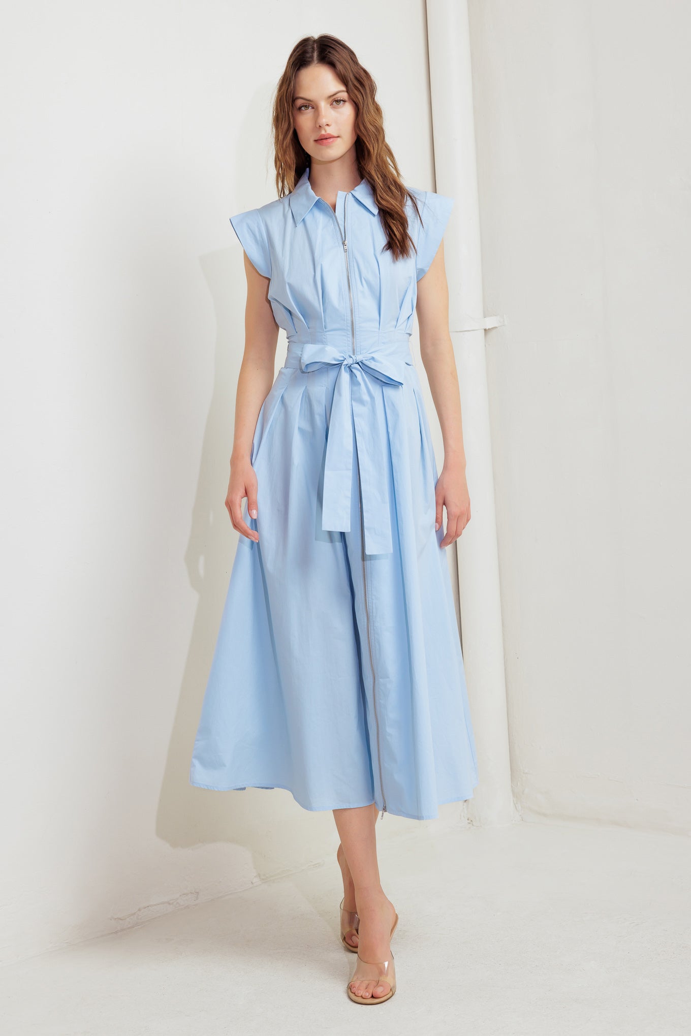 A solid woven midi dress featuring collar, short sleeve, front zipper closure and self sash tie