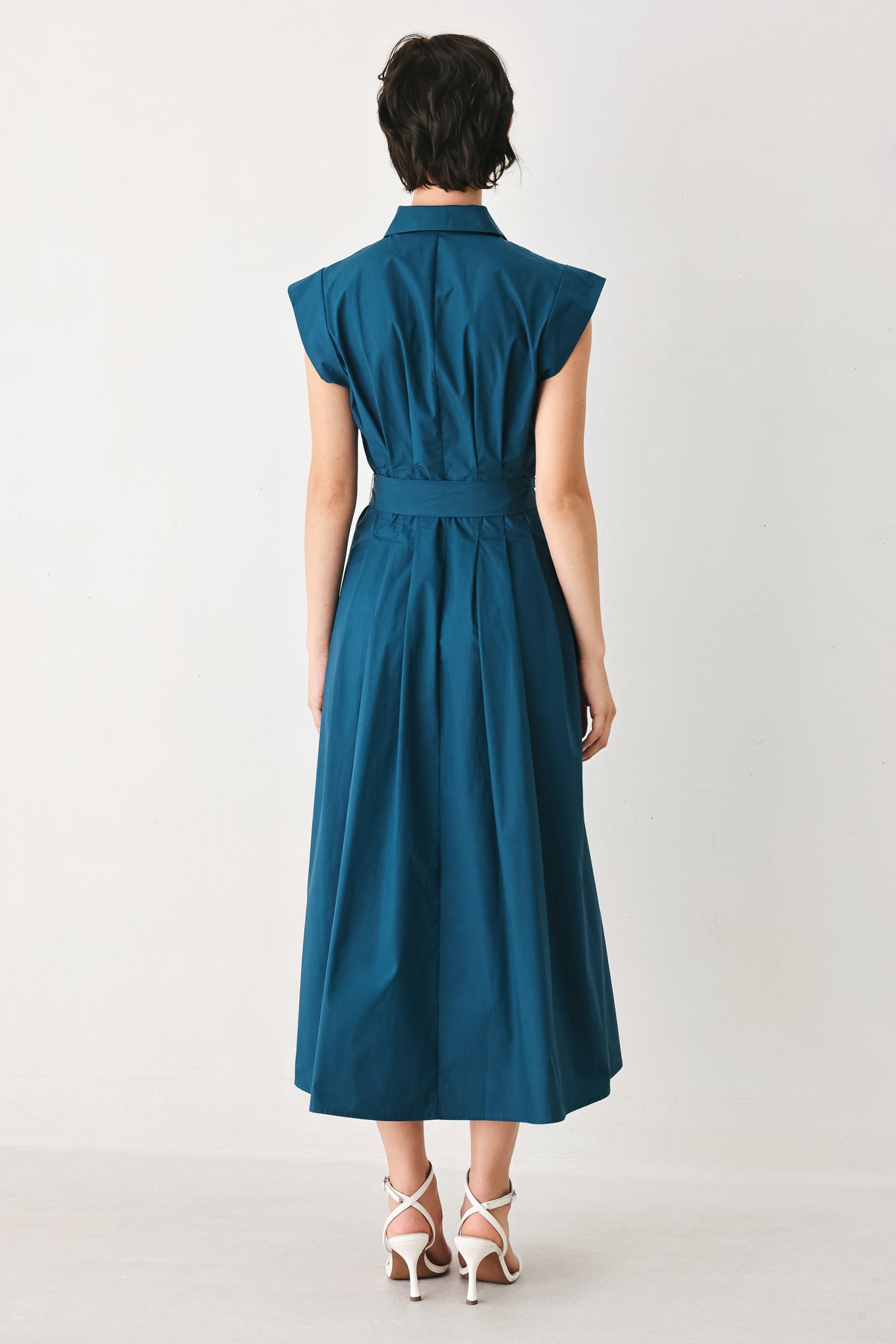 Woman wearing a teal midi dress featuring collar, short sleeve, front zipper closure and self sash tie | FREEMARKET