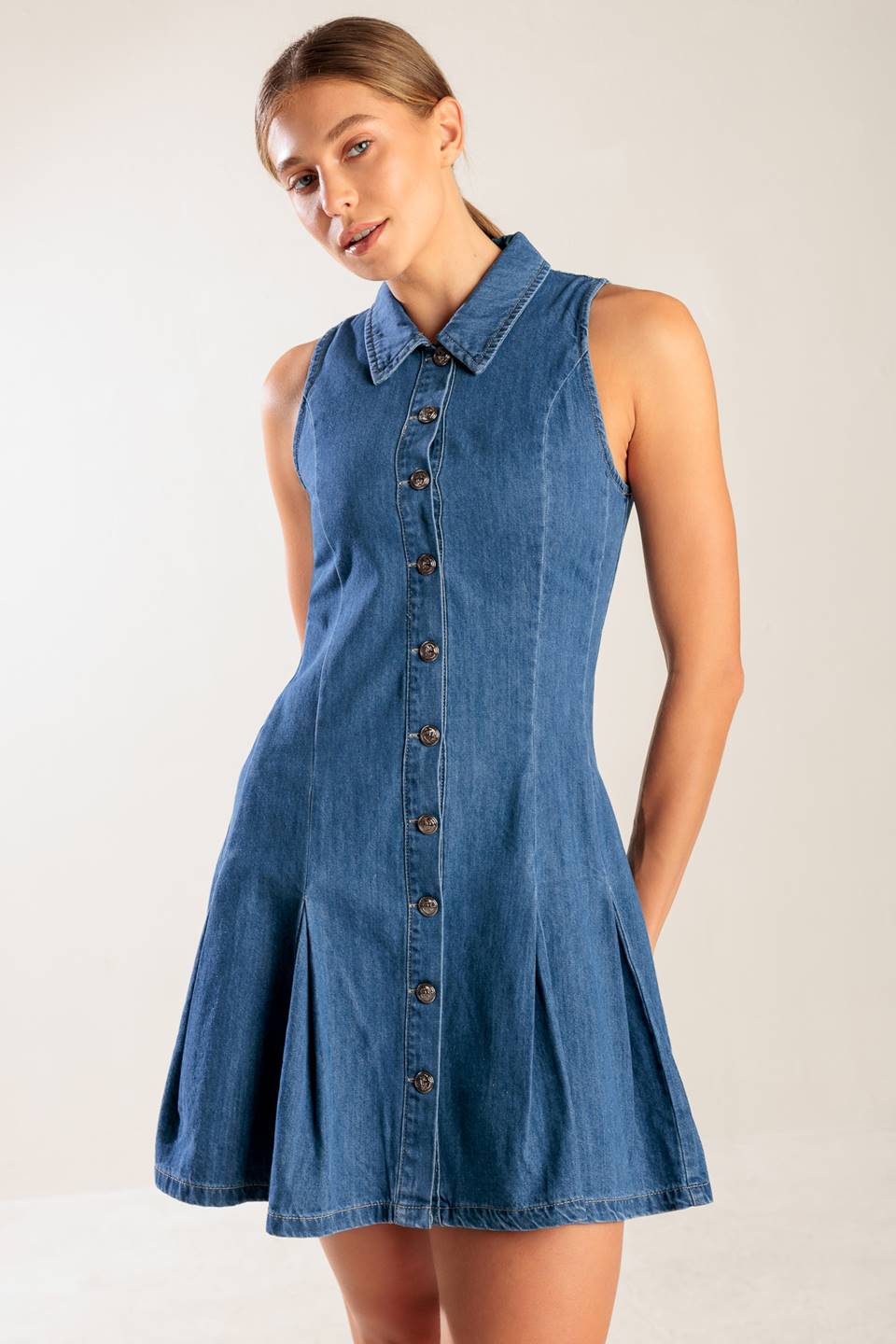 A washed denim mini dress featuring collar, button down, fitted waist and inverted pleats