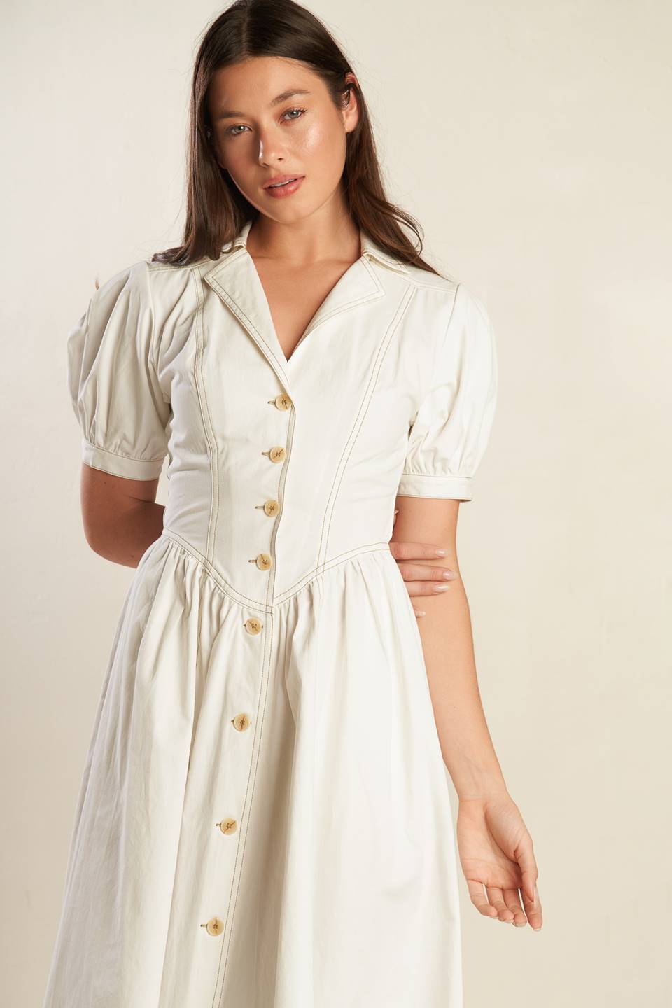 A solid off-white woven midi dress featuring collar, button down, short puff sleeve with cuff and full skirt.