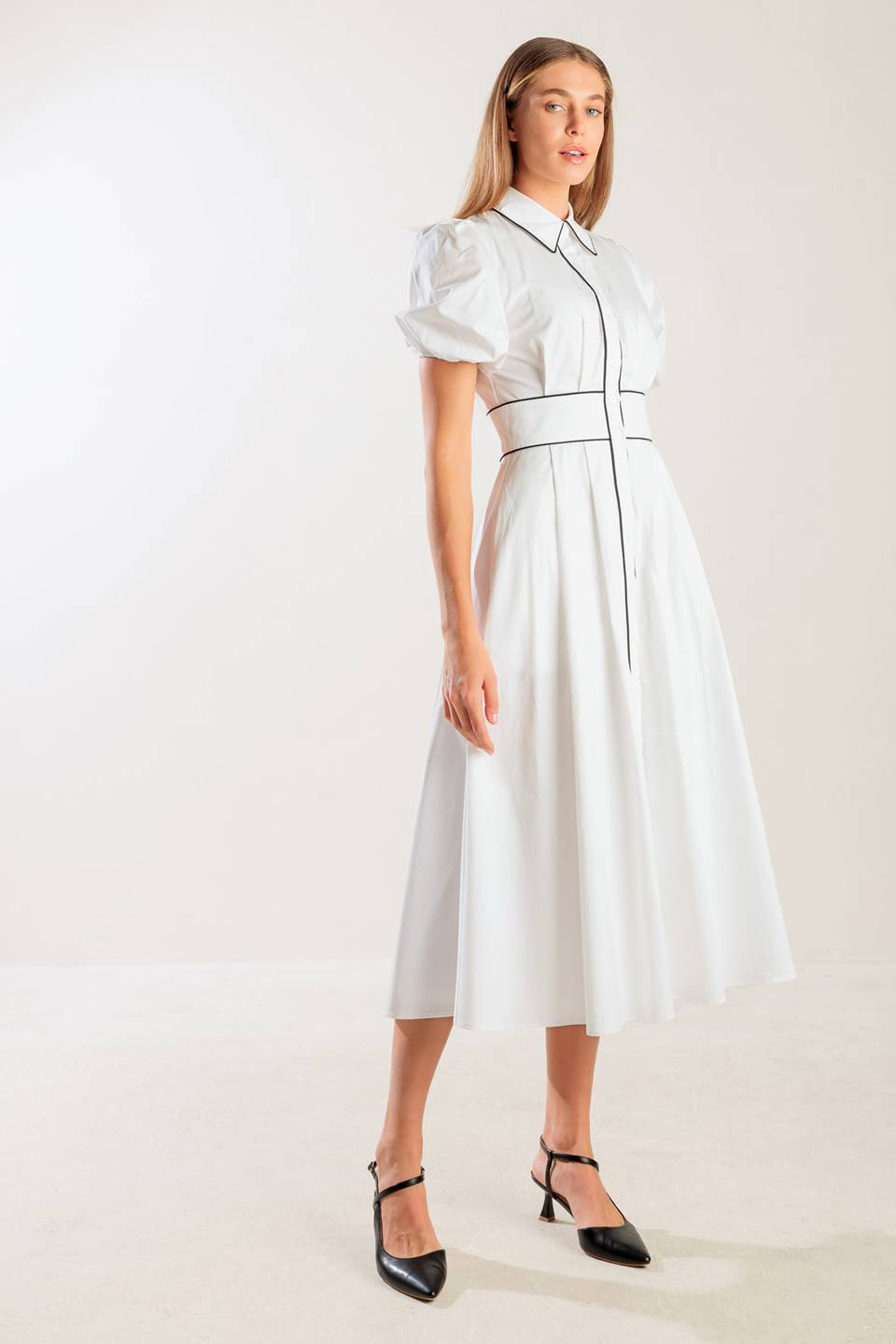 A solid woven midi featuring collar, button down, short puff sleeve, contrasting piping detail and full skirt