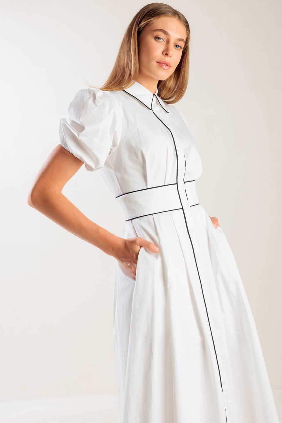 A solid woven midi featuring collar, button down, short puff sleeve, contrasting piping detail and full skirt