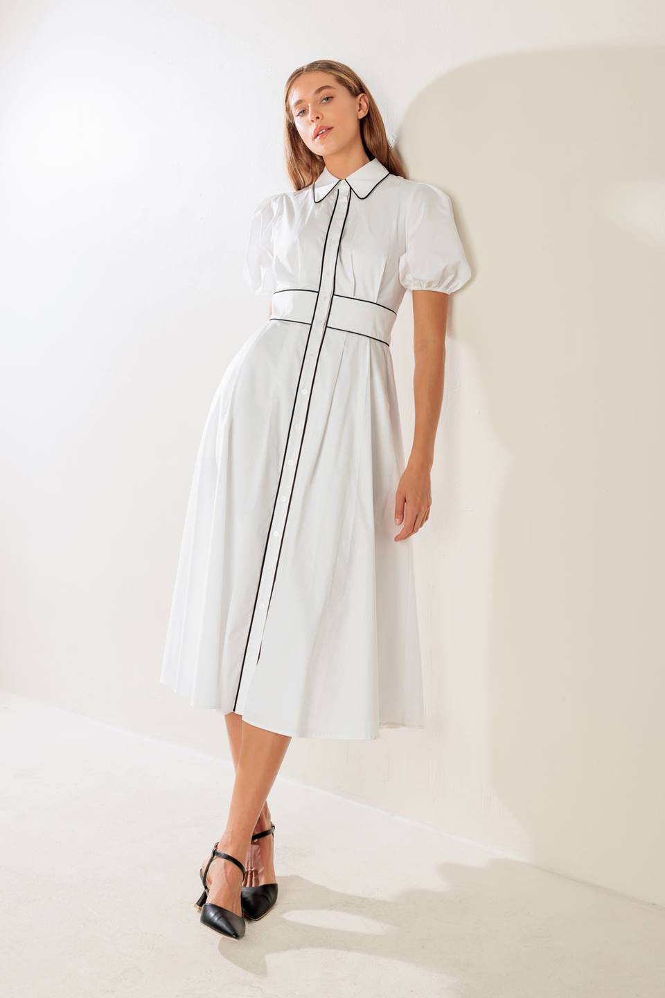 A solid woven midi featuring collar, button down, short puff sleeve, contrasting piping detail and full skirt