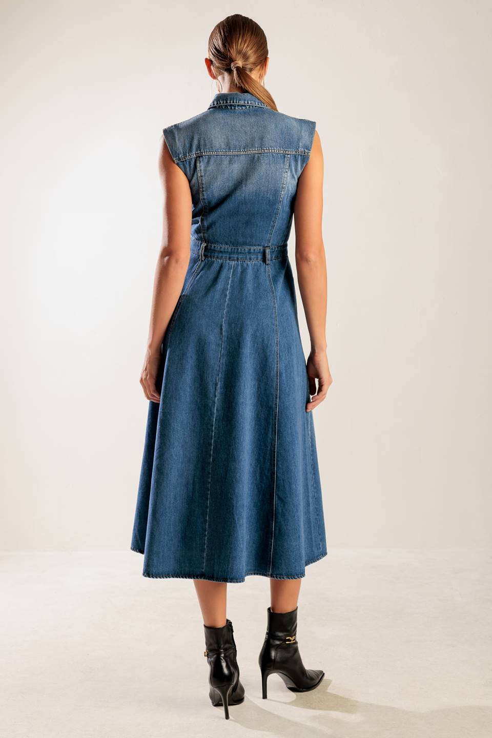 A washed denim midi dress featuring collar, sleeveless, button down, pockets and A line skirt