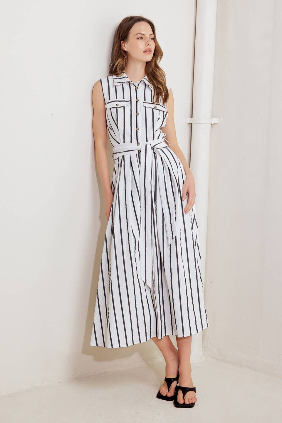 A striped woven midi dress featuring collar, sleeveless, button down, front pocket, self sash tie and full circle skirt