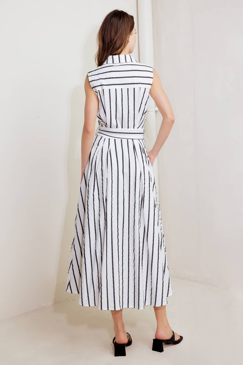 A striped woven midi dress featuring collar, sleeveless, button down, front pocket, self sash tie and full circle skirt
