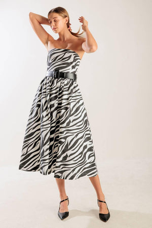 A strapless, black and white, zebra print woven midi dress featuring contrasting belt, side pockets, full skirt, and back zipper closure