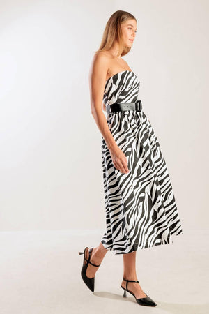 A strapless, black and white, zebra print woven midi dress featuring contrasting belt, side pockets, full skirt, and back zipper closure
