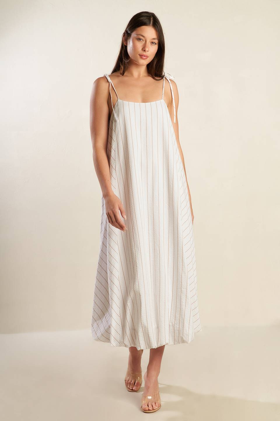 A striped woven midi dress featuring cami top with shoulder ties, bubble hem and button back.