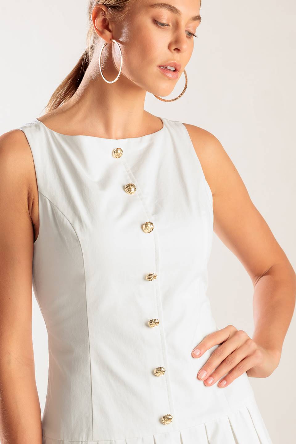 A solid white woven mini dress featuring square neckline, sleeveless, button down detail, box pleated skirt and back zipper closure