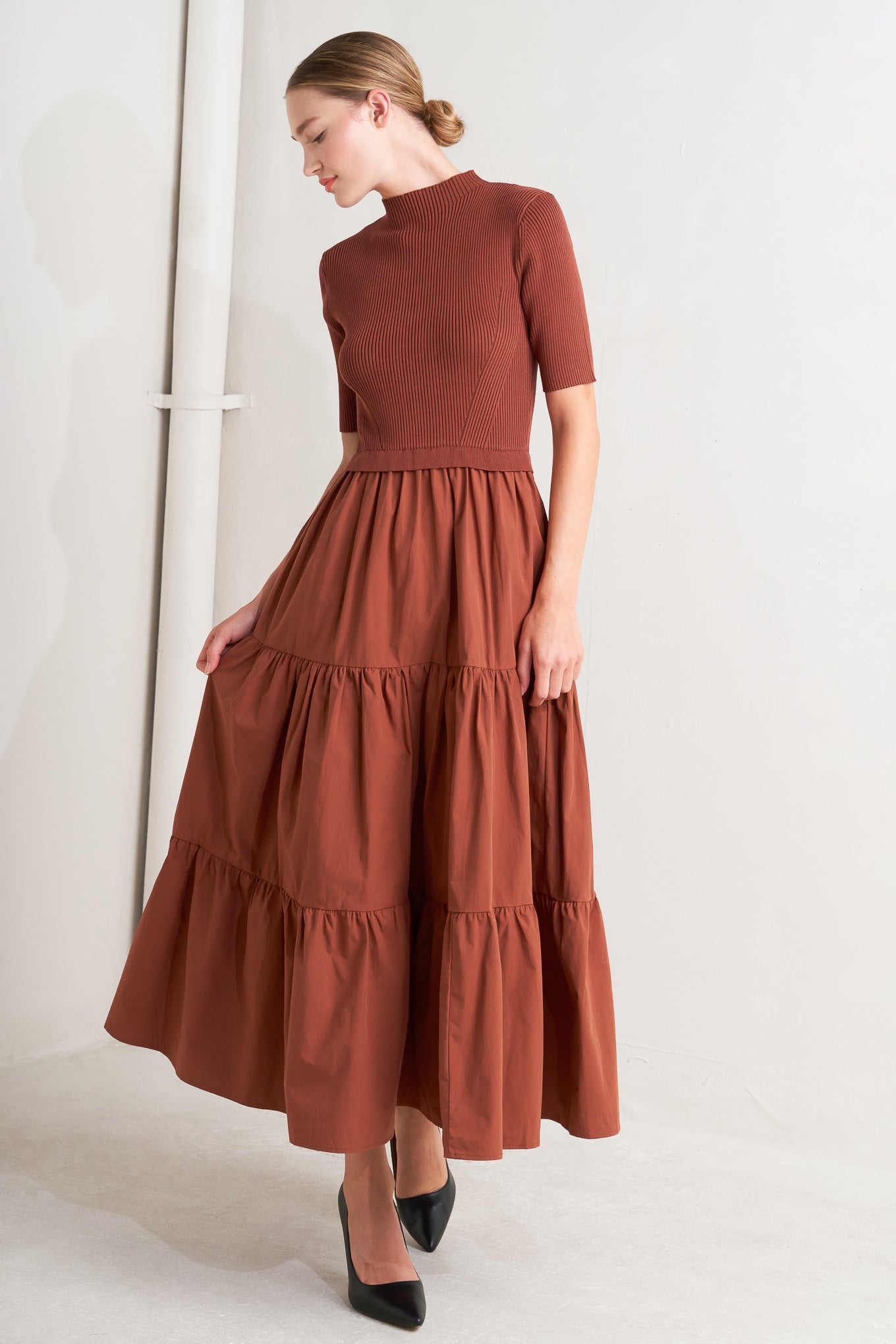 A sweater knit and woven combination midi dress featuring ribbed top with high neckline and short sleeve and tiered woven skirt