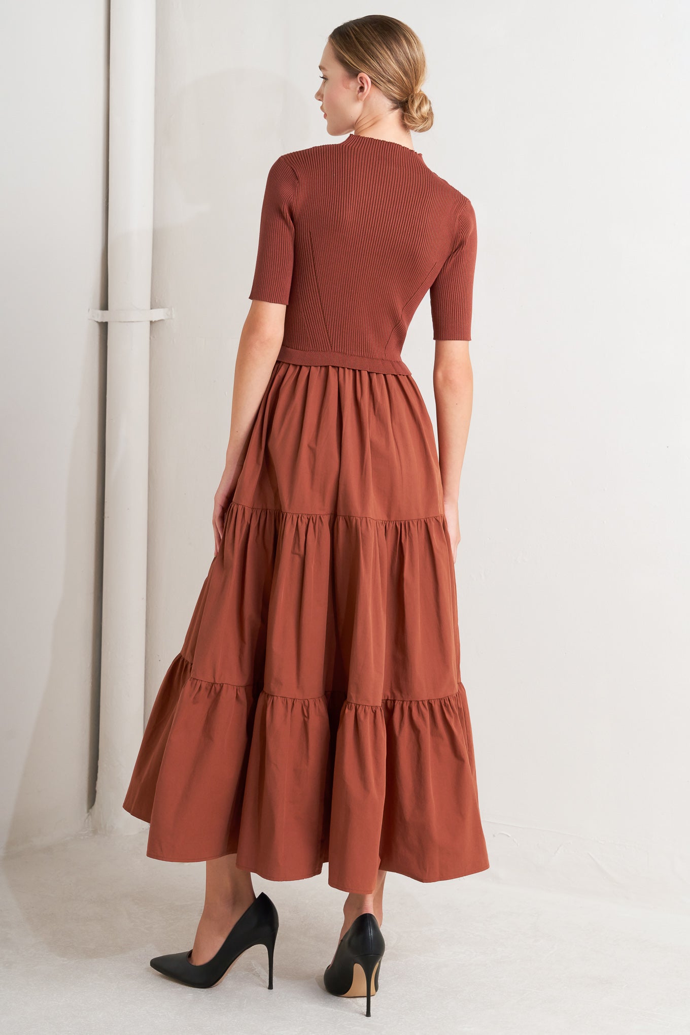 A sweater knit and woven combination midi dress featuring ribbed top with high neckline and short sleeve and tiered woven skirt