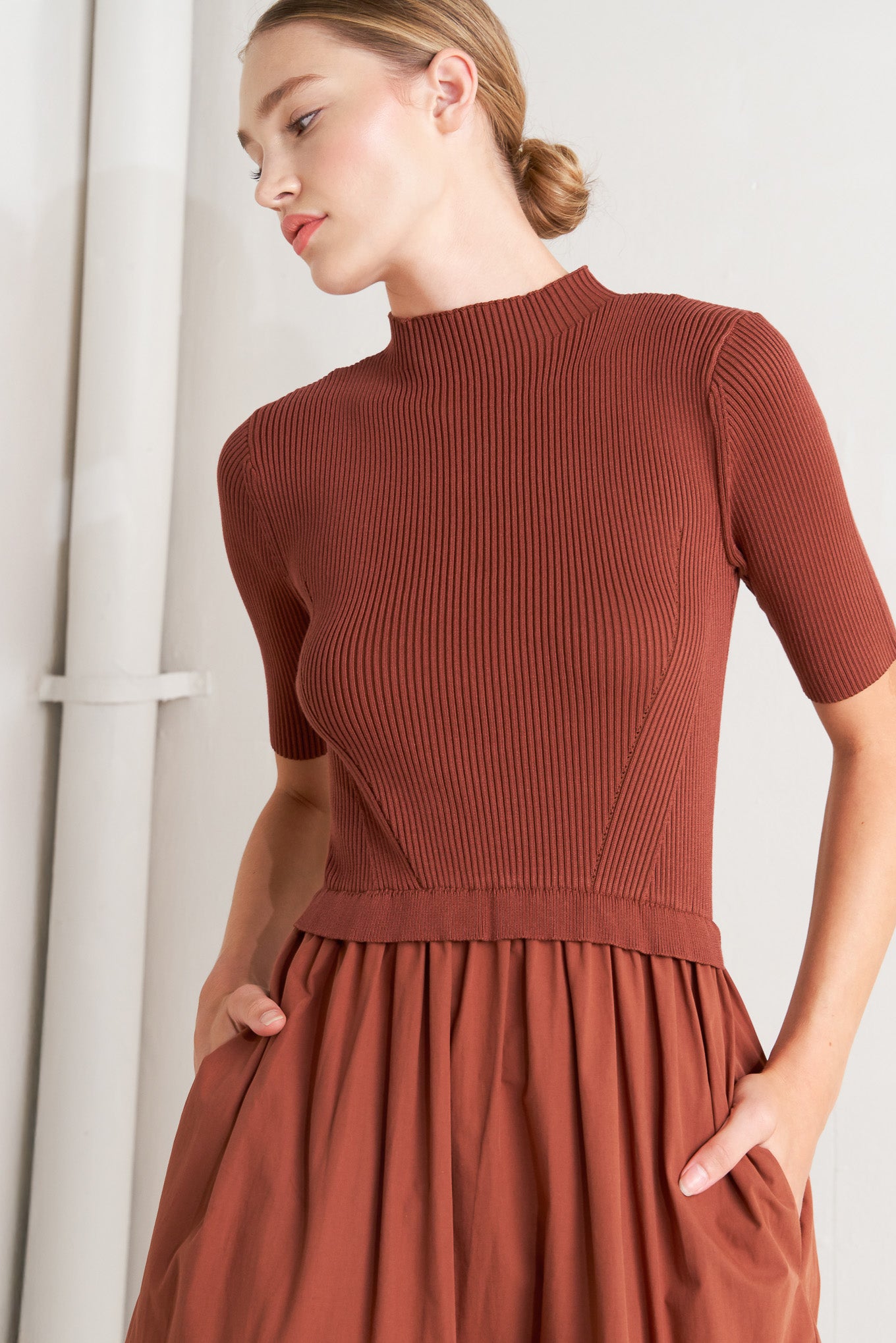 A sweater knit and woven combination midi dress featuring ribbed top with high neckline and short sleeve and tiered woven skirt