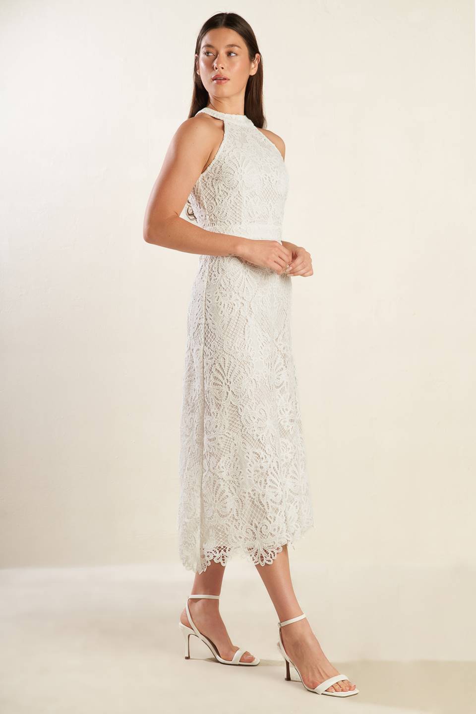 A white woven lace midi dress featuring halter neckline, A-line skirt and back zipper closure.