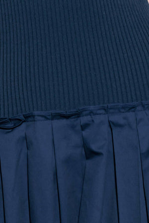 A ribbed sweater knit top and woven skirt combination dress featuring U neckline and sleeveless.