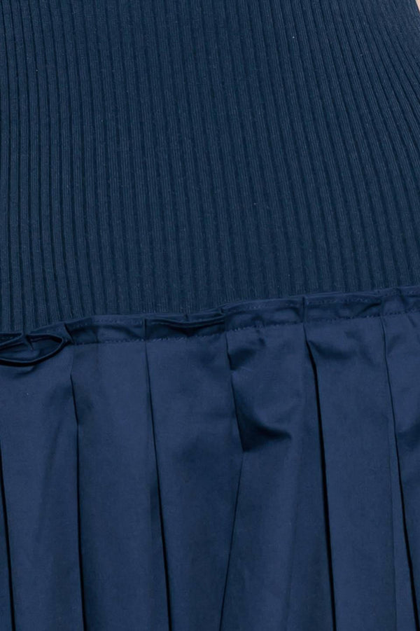 A ribbed sweater knit top and woven skirt combination dress featuring U neckline and sleeveless.
