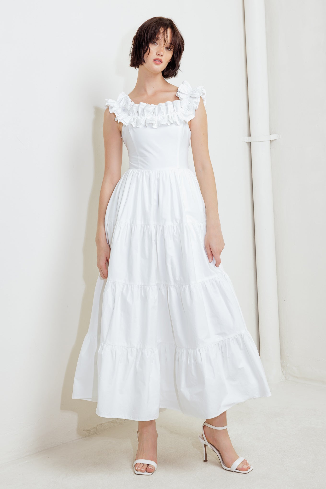 A solid woven midi dress featuring ruffled neckline, tiered skirt, smocked back bodice and tie closure
