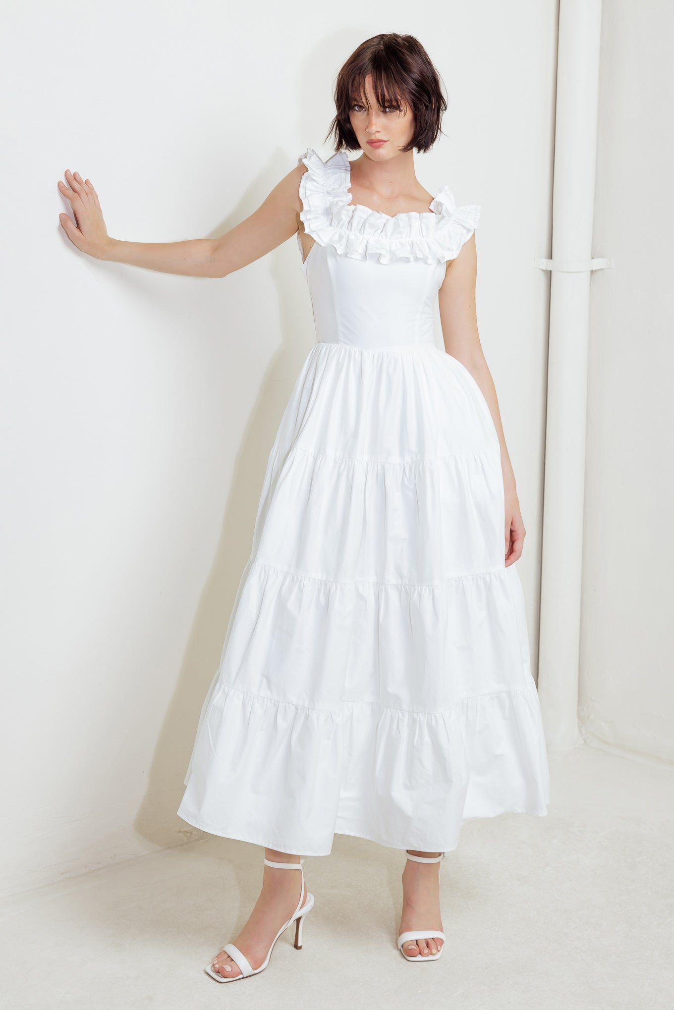 A solid woven midi dress featuring ruffled neckline, tiered skirt, smocked back bodice and tie closure