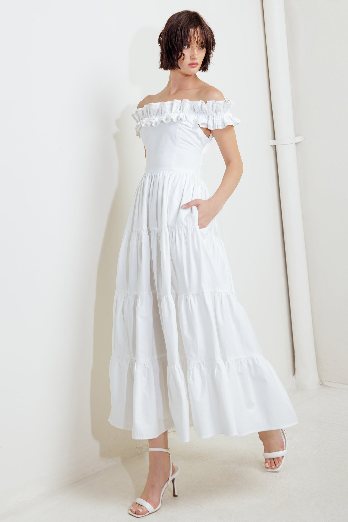 A solid woven midi dress featuring ruffled neckline, tiered skirt, smocked back bodice and tie closure