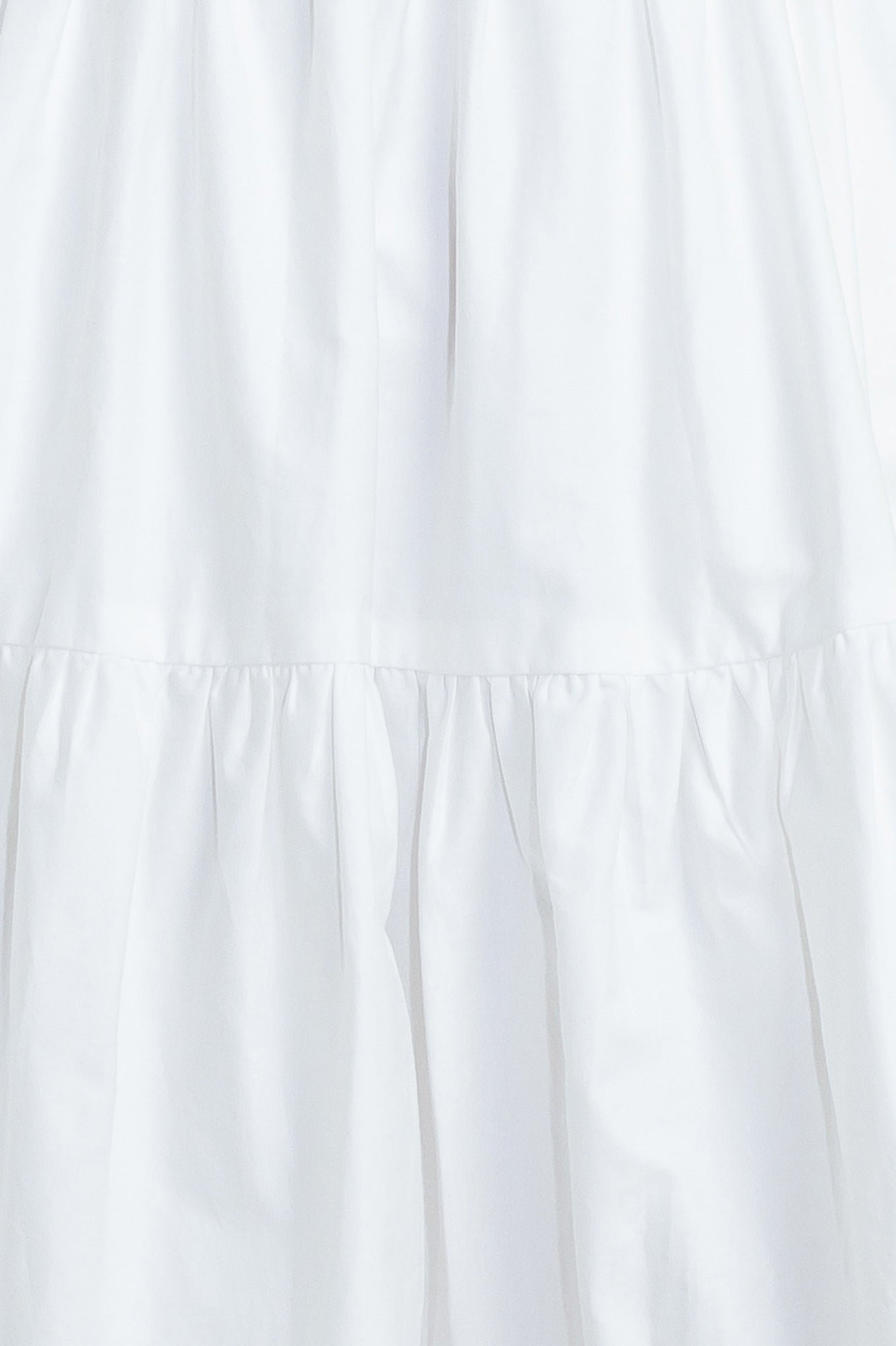 A solid woven midi dress featuring ruffled neckline, tiered skirt, smocked back bodice and tie closure