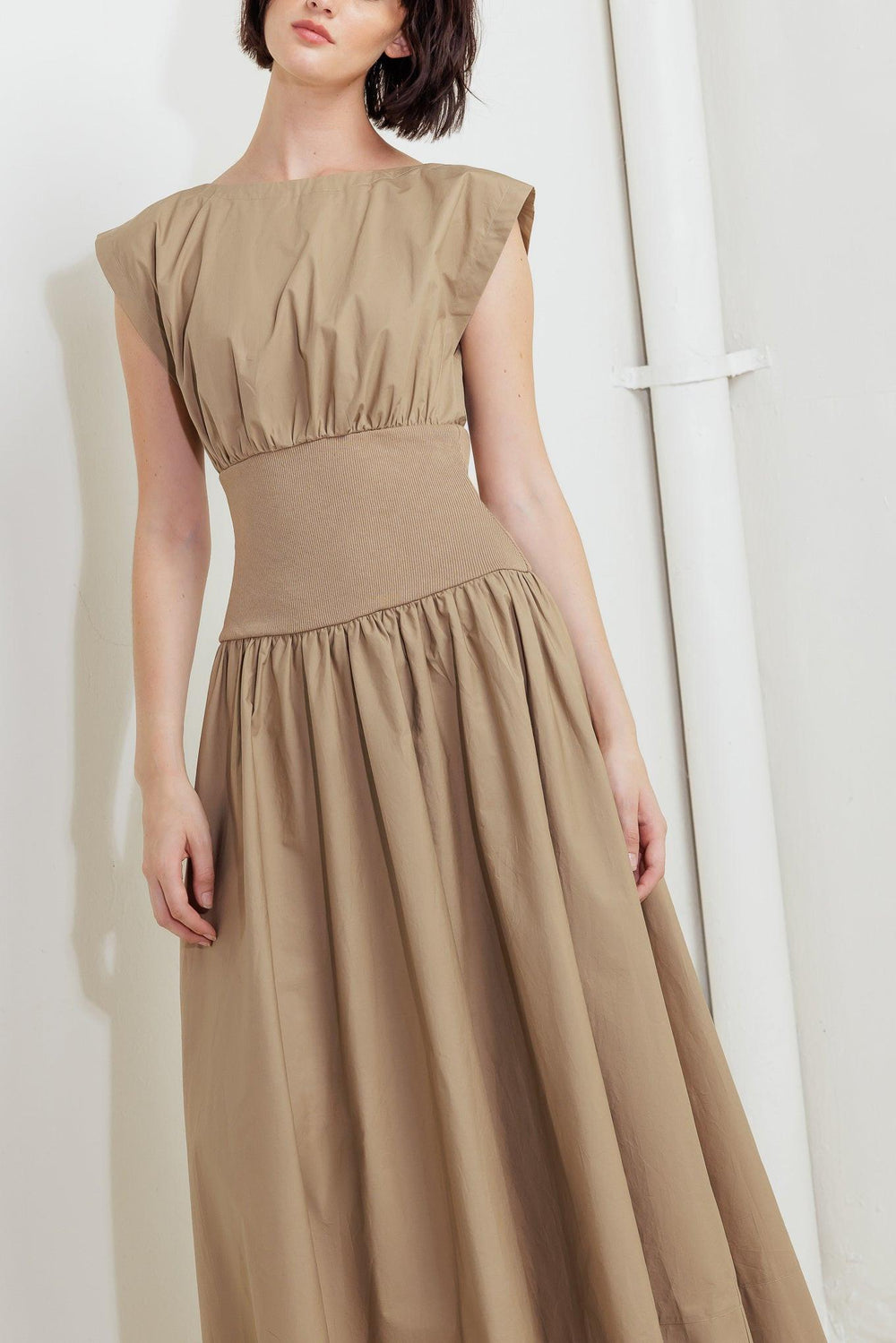 A solid woven midi dress featuring wide neckline, short sleeve, knit midriff, full skirt and back zipper closure